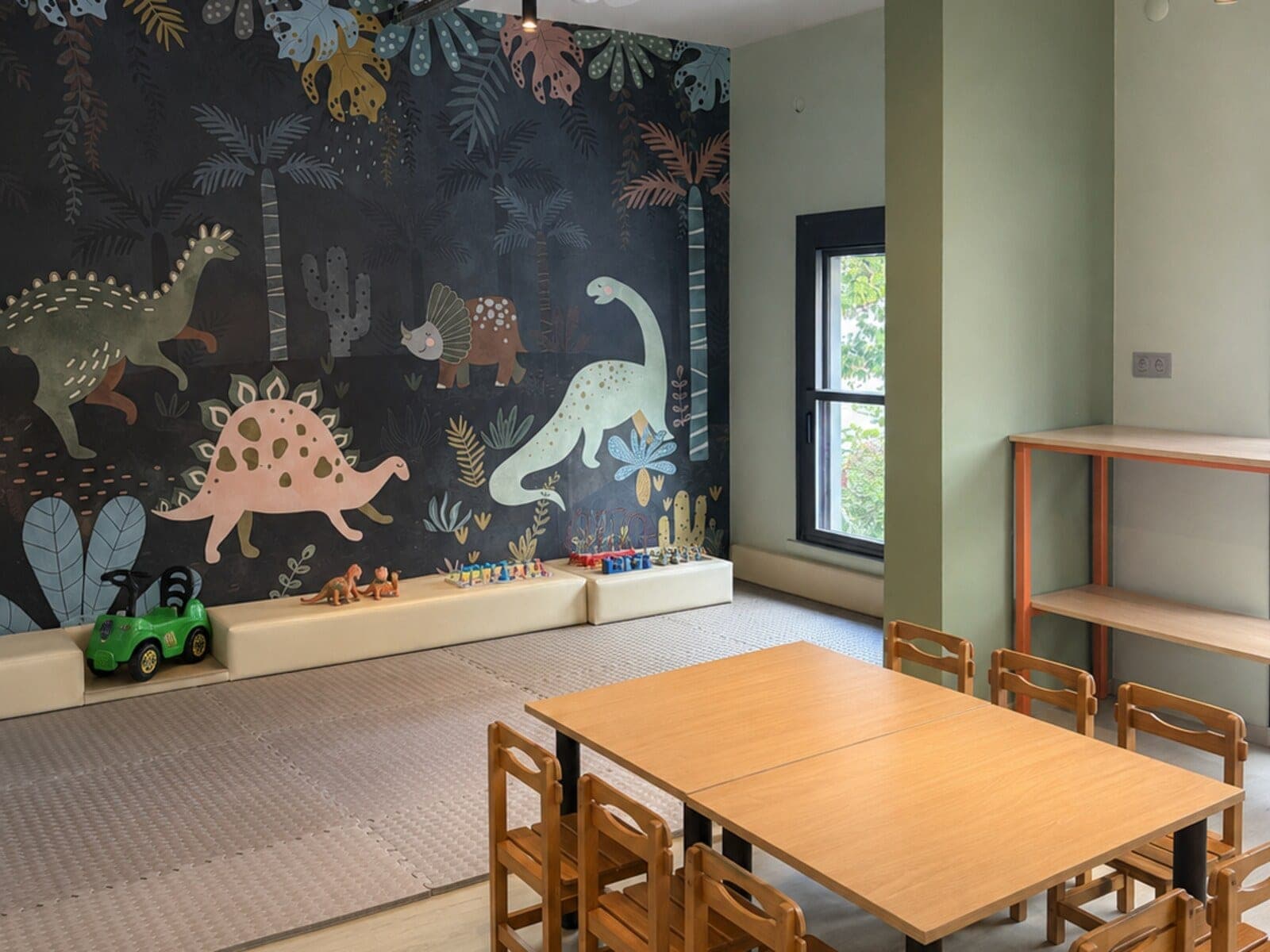 Dinozor duvar resimli Bambola etkinlik salonu ve çocuk boyu ahşap masalar